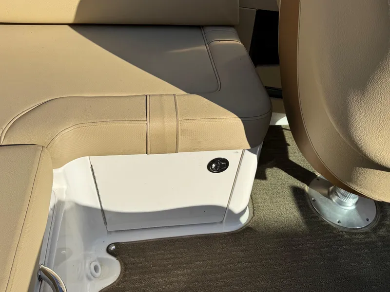 Slide: The Image of 2015 Sea Ray 220 Sundeck interior seating with beige upholstery and carpeted flooring. - 16