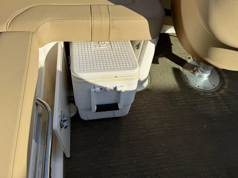 Slide: The Image of 2015 Sea Ray 220 Sundeck interior with cooler storage under beige seating. - 17