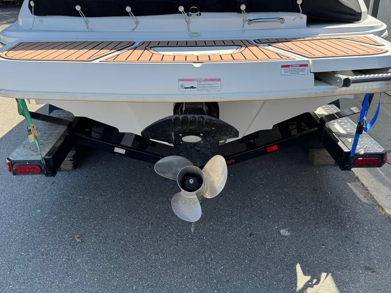 Slide: The Image of 2015 Sea Ray 220 Sundeck boat on trailer, rear view with propeller visible. - 4