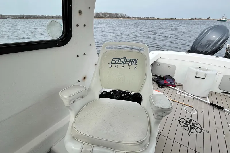Slide: The Image of 2007 Eastern 27 boat interior with branded seat, docked on calm water. - 13