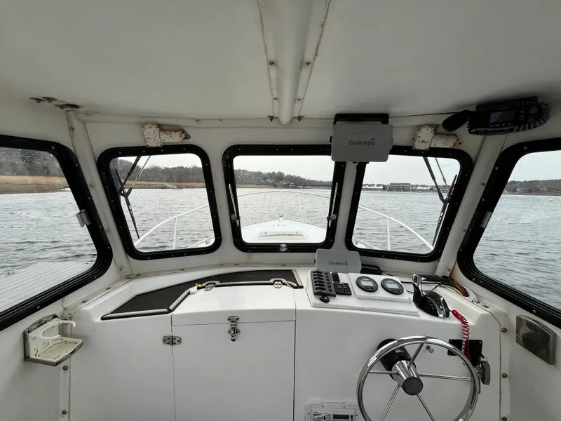 Slide: The Image of Interior view of 2007 Eastern 27 boat cockpit with steering wheel and navigation equipment. - 14