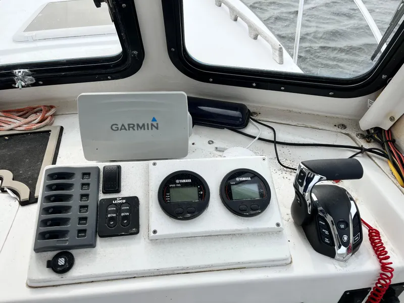 Slide: The Image of Boat dashboard with Garmin GPS, controls, and gauges on a 2007 Eastern 27 model. - 16