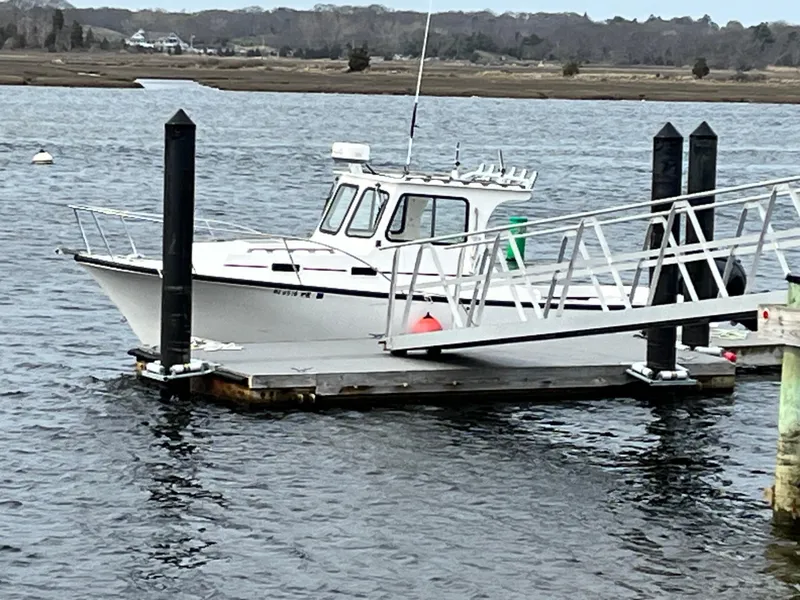 Slide: The Image of 2007 Eastern 27 boat docked on calm water with a floating pier. - 7