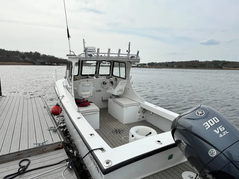 Slide: The Image of 2007 Eastern 27 boat docked, featuring a Yamaha 300 V6 engine, on a calm waterway. - 8