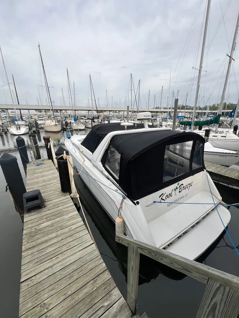 Slide: The Image of 1991 Sea Ray 350 Sundancer docked at marina, featuring black canopy and sleek design. - 10
