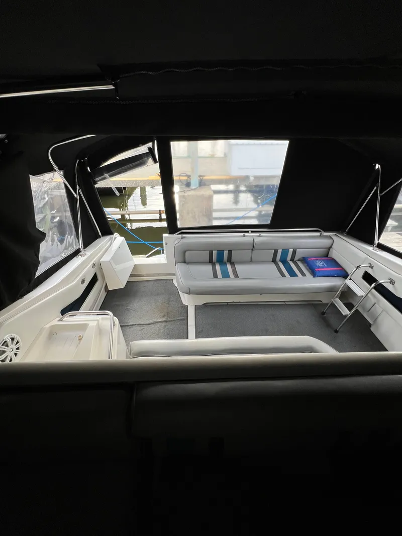 Slide: The Image of 1991 Sea Ray 350 Sundancer interior with cushioned seating and striped pillows. - 13