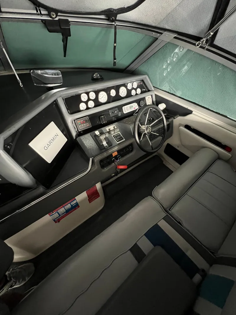 Slide: The Image of 1991 Sea Ray 350 Sundancer helm with steering wheel, gauges, and Garmin navigation system. - 15