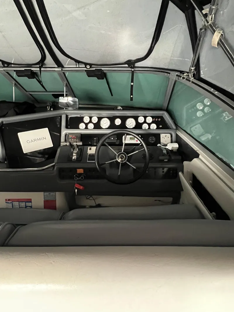 Slide: The Image of 1991 Sea Ray 350 Sundancer cockpit with steering wheel, gauges, and Garmin navigation system. - 16