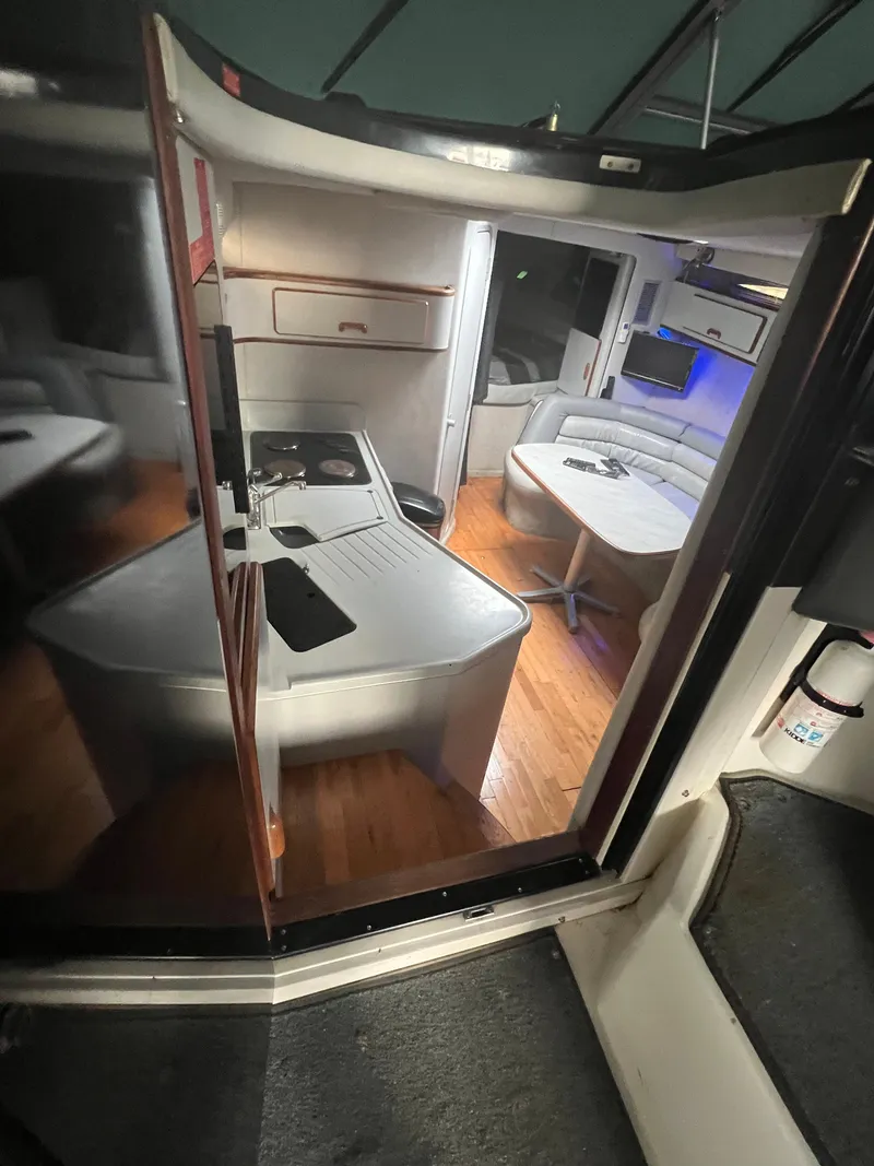 Slide: The Image of Interior of a 1991 Sea Ray 350 Sundancer yacht, featuring a modern kitchen and seating area. - 19