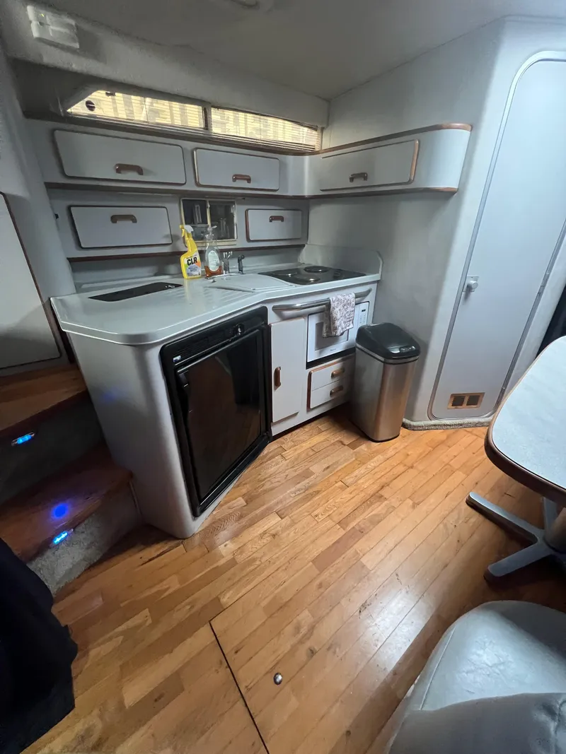 Slide: The Image of 1991 Sea Ray 350 Sundancer kitchen with wood flooring, cabinets, and appliances. - 21