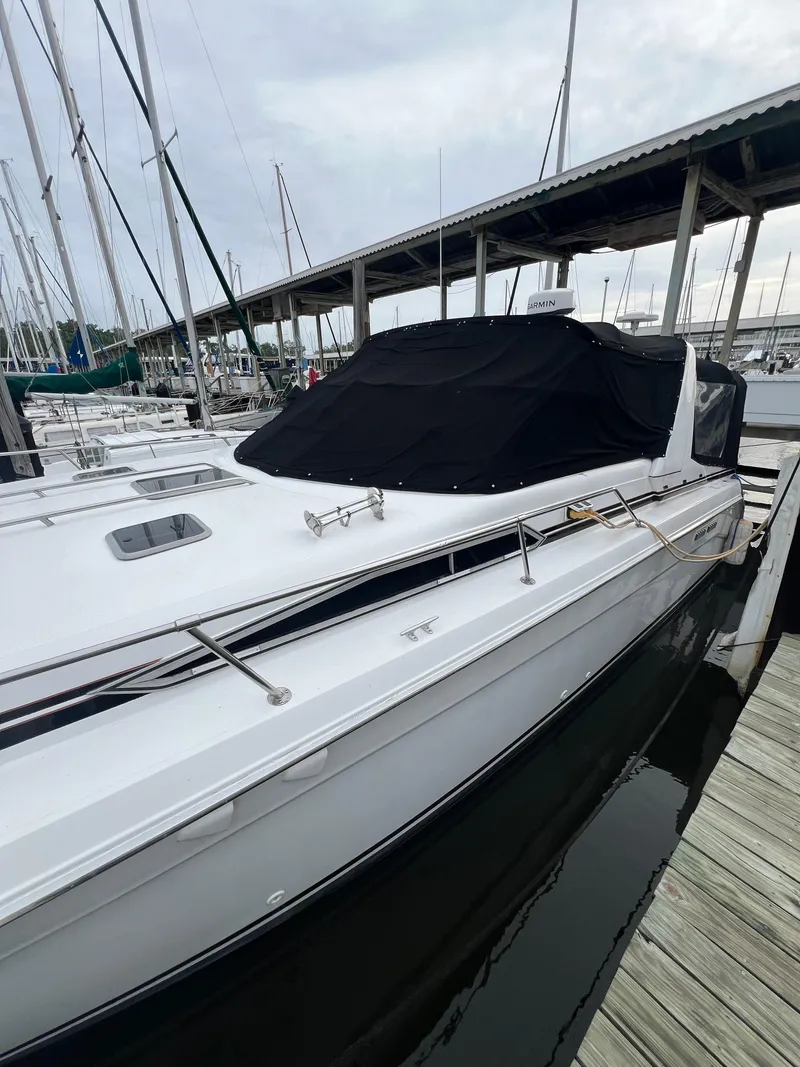 Slide: The Image of 1991 Sea Ray 350 Sundancer docked at marina, covered with black tarp. - 8