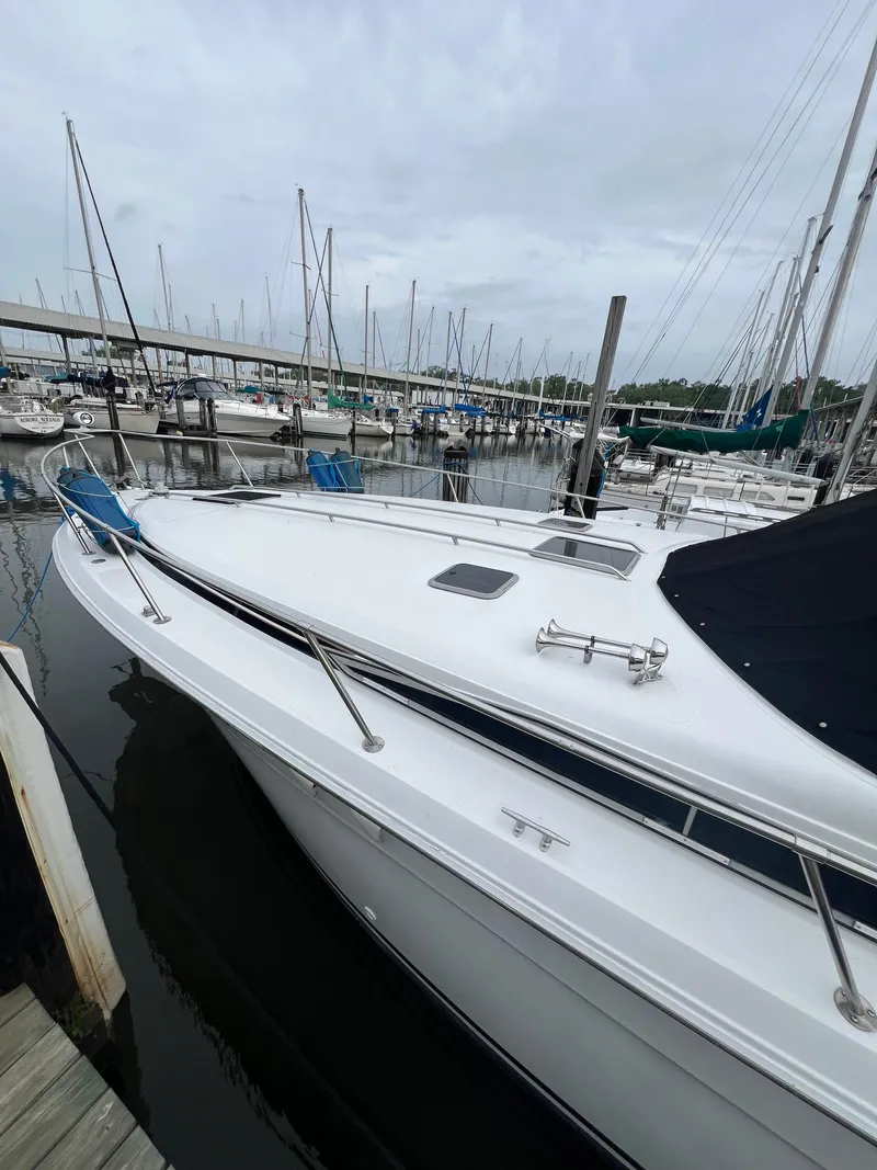 Slide: The Image of 1991 Sea Ray 350 Sundancer docked at marina, overcast sky, sailboats in background. - 9