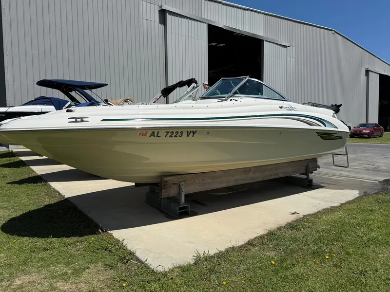 Slide: The Image of 2001 Sea Ray 210 SD boat on display outside a large storage building. - 0