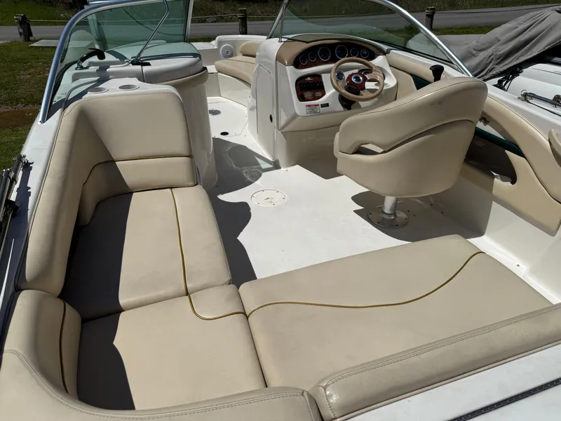 Slide: The Image of 2001 Sea Ray 210 SD boat interior with beige seating and steering console. - 10