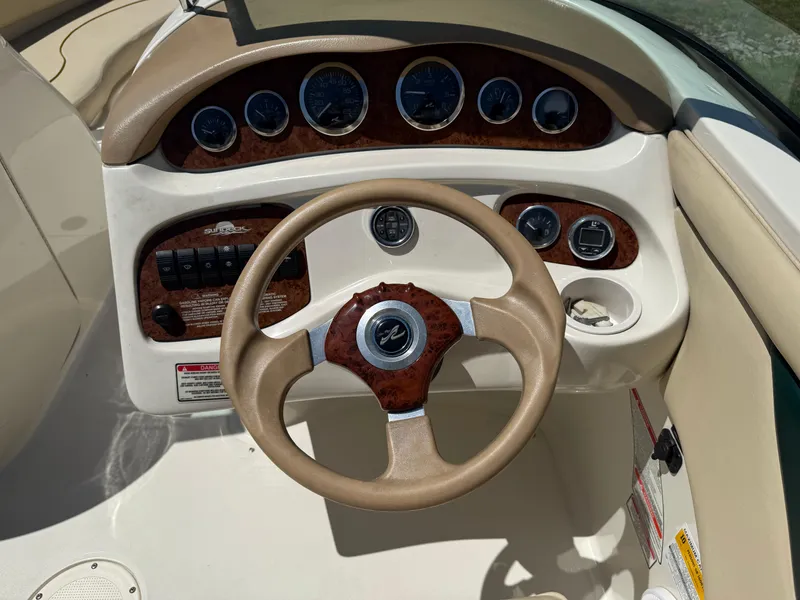 Slide: The Image of Steering console of a 2001 Sea Ray 210 SD boat, featuring gauges and controls. - 9