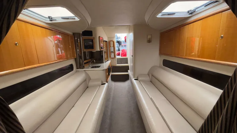 Slide: The Image of Luxurious interior of a 2002 Black Thunder 460 EC boat with plush seating and wood cabinetry. - 12