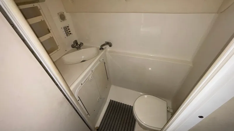 Slide: The Image of Compact bathroom in a 2002 Black Thunder 460 EC boat, featuring sink and toilet. - 14