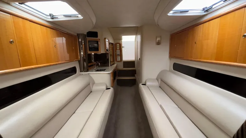 Slide: The Image of Interior of 2002 Black Thunder 460 EC boat with beige seating and wooden cabinets. - 16
