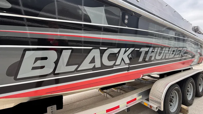 Slide: The Image of 2002 Black Thunder 460 EC boat with bold branding on trailer. - 4