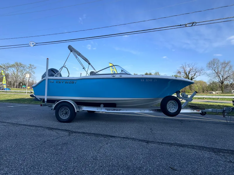 Slide: The Image of 2023 Key West 203 DFS boat on trailer, blue hull, parked outdoors. - 1