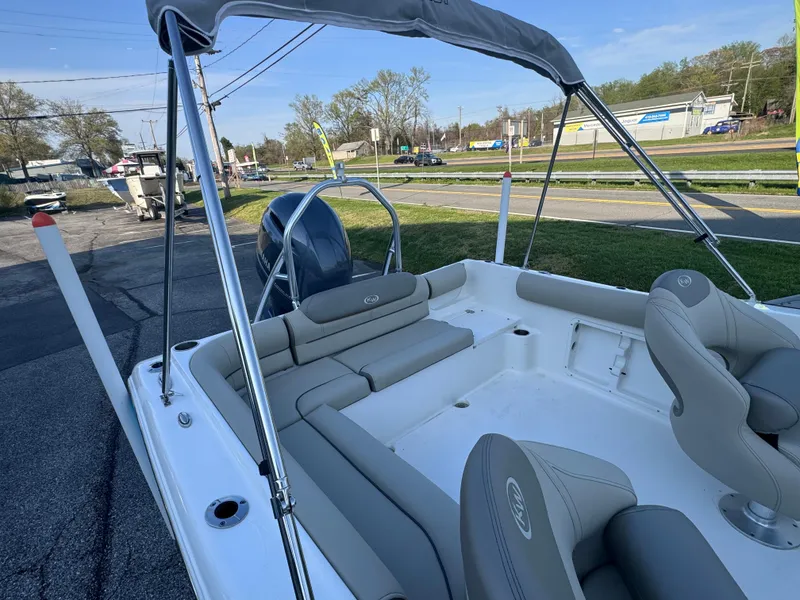 Slide: The Image of 2023 Key West 203 DFS boat interior with seating and canopy, parked outdoors. - 18