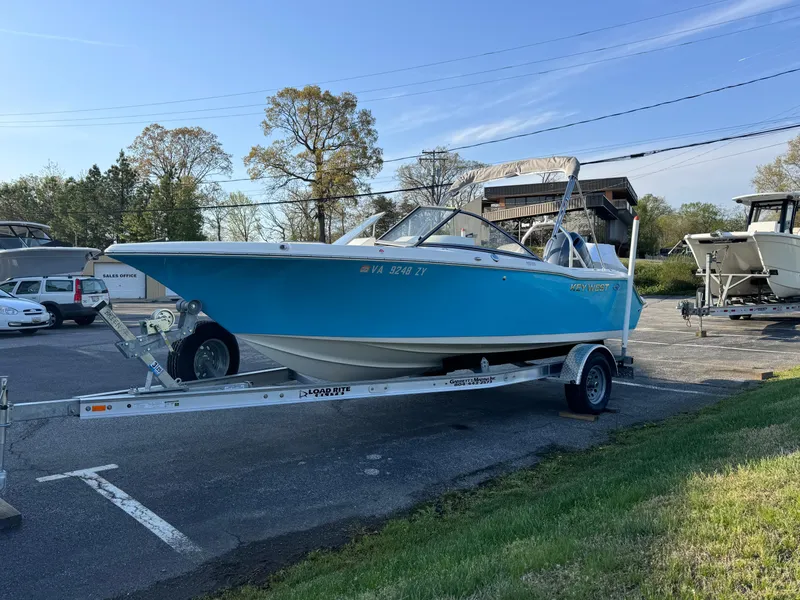 Slide: The Image of 2023 Key West 203 DFS boat on trailer in parking lot, blue hull, sunny day. - 2