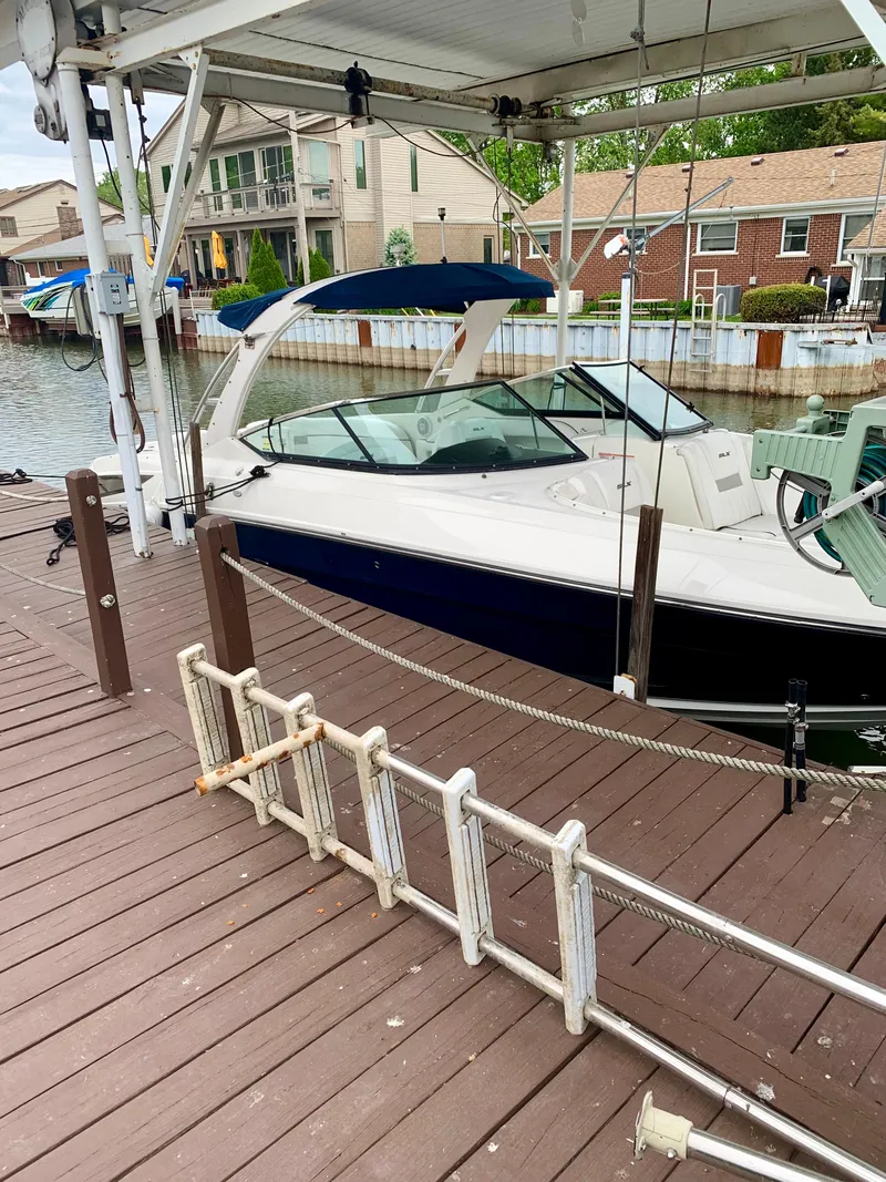 Slide: The Image of 2009 Sea Ray 300 SLX boat docked at a marina with wooden decking. - 12