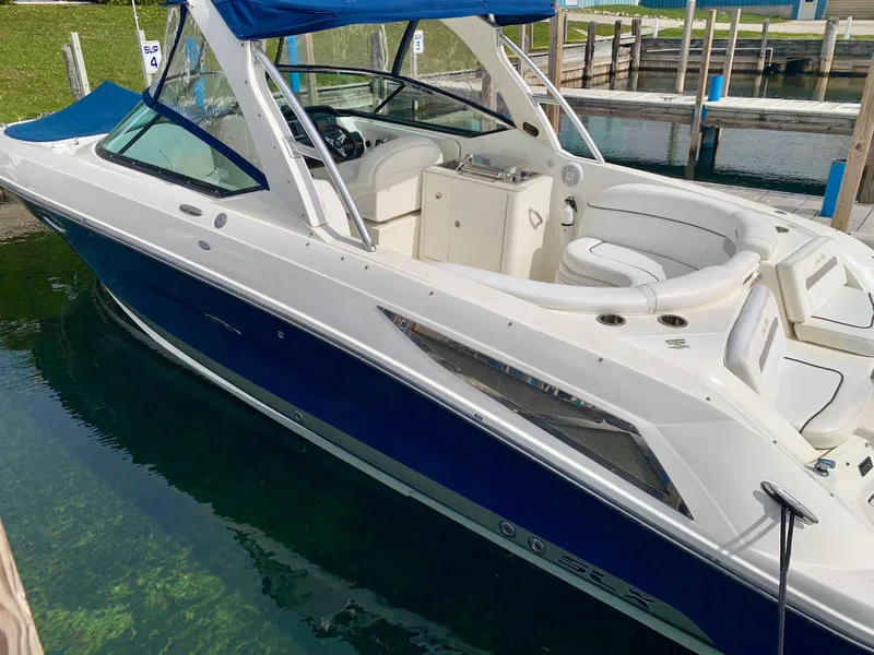 Slide: The Image of 2009 Sea Ray 300 SLX boat with blue and white exterior docked in clear water. - 3