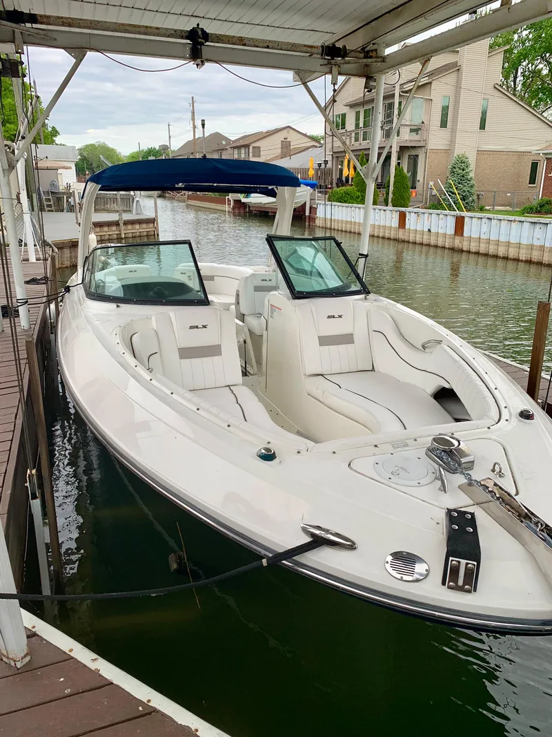 Slide: The Image of 2009 Sea Ray 300 SLX boat docked in a canal, featuring sleek design and spacious seating. - 4