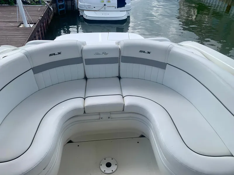 Slide: The Image of 2009 Sea Ray 300 SLX boat with white cushioned seating by the water. - 9