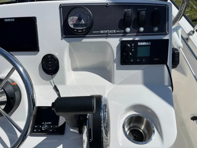 Slide: The Image of 2024 Boston Whaler 150 Montauk dashboard with Simrad electronics and control panel. - 11