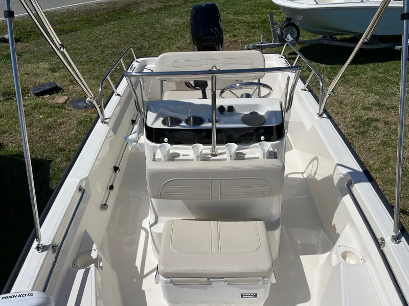 Slide: The Image of 2024 Boston Whaler 150 Montauk boat interior with seating and steering console. - 14