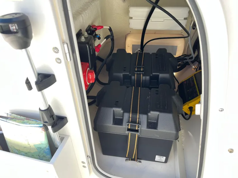 Slide: The Image of 2024 Boston Whaler 150 Montauk battery compartment with secured battery and wiring. - 16