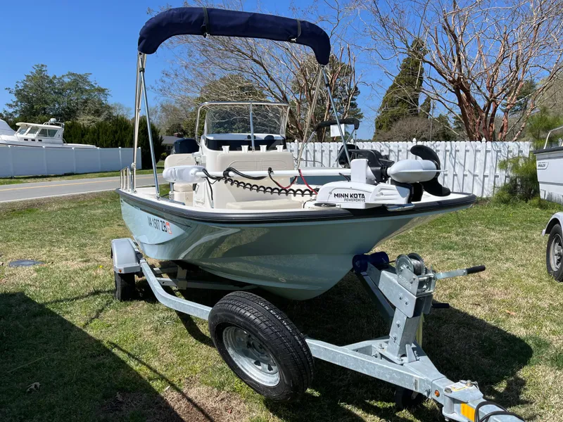 Slide: The Image of 2024 Boston Whaler 150 Montauk boat on trailer, parked on grass. - 21