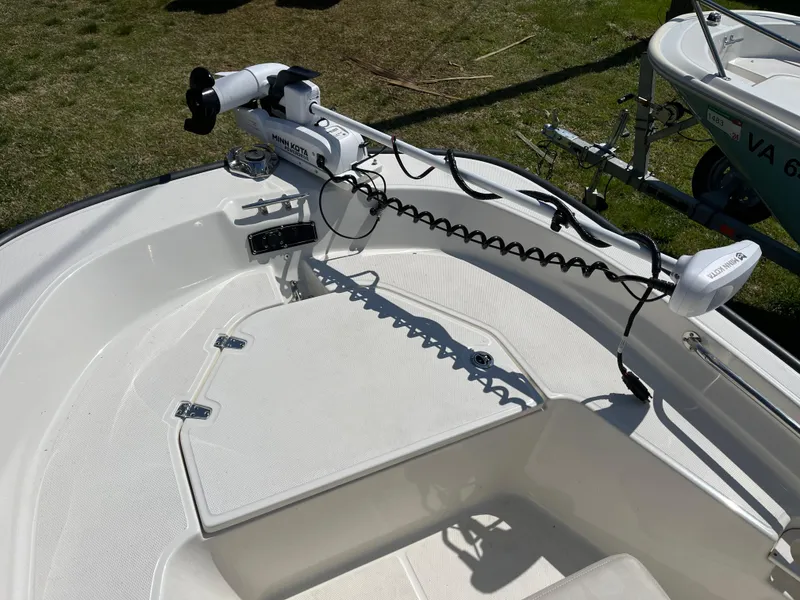 Slide: The Image of 2024 Boston Whaler 150 Montauk boat deck with trolling motor, on grass. - 7