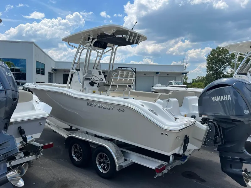 Slide: The Image of 2024 Key West 239 FS boat on trailer, displayed outdoors with Yamaha engine. - 2