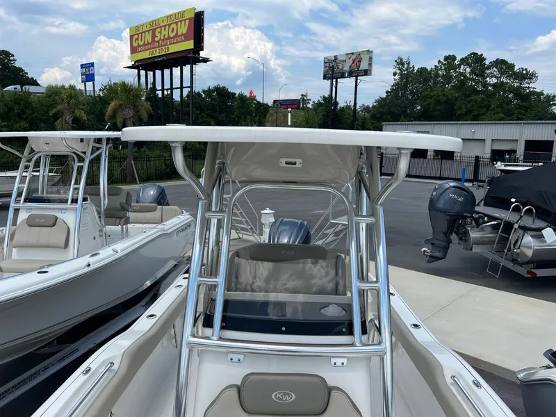 Slide: The Image of 2024 Key West 239 FS boat with T-top, parked outdoors, clear sky background. - 20