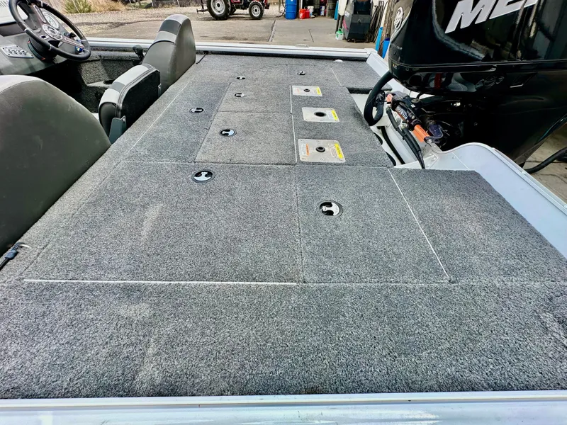 Slide: The Image of 2018 Lund 1875 Pro-V Bass boat with carpeted deck and storage compartments. - 13
