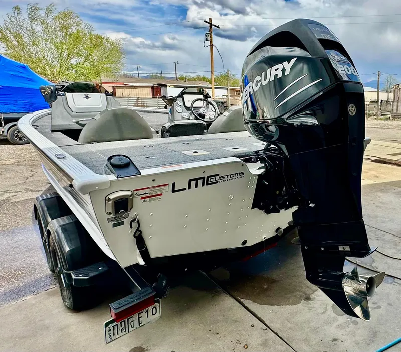 Slide: The Image of 2018 Lund 1875 Pro-V Bass boat with Mercury outboard motor, parked outdoors. - 3