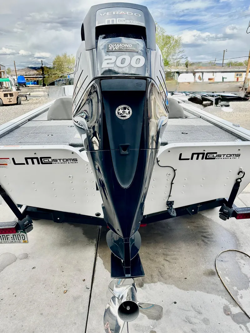 Slide: The Image of 2018 Lund 1875 Pro-V Bass boat with Mercury 200 engine, parked outdoors. - 4