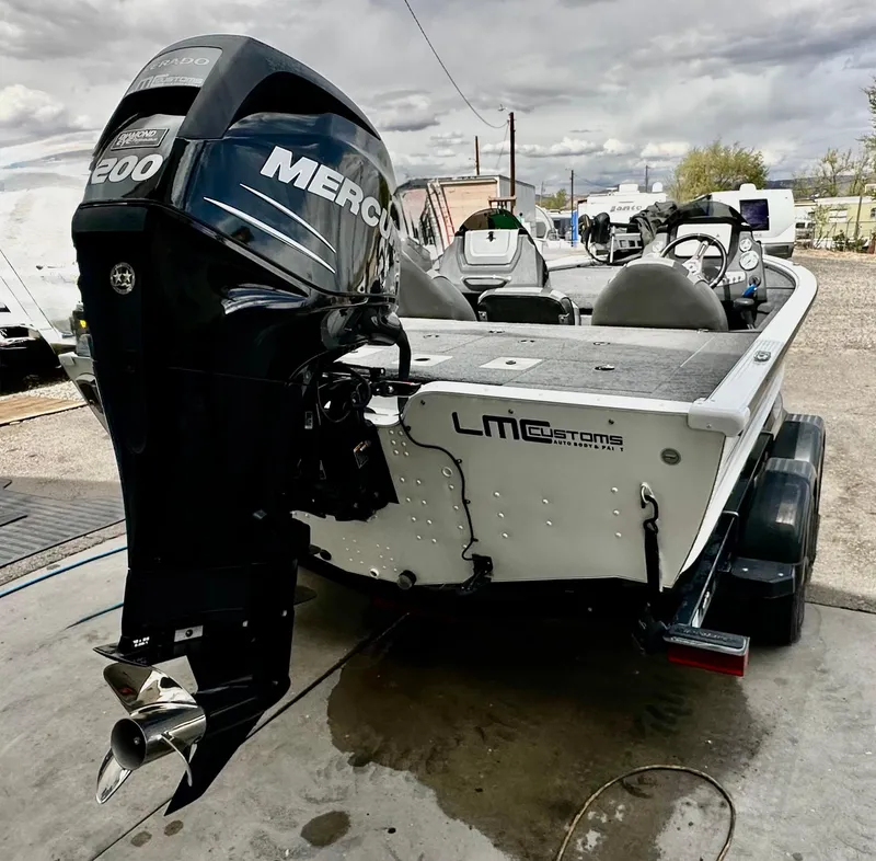 Slide: The Image of 2018 Lund 1875 Pro-V Bass boat with Mercury 200 engine, parked outdoors. - 5
