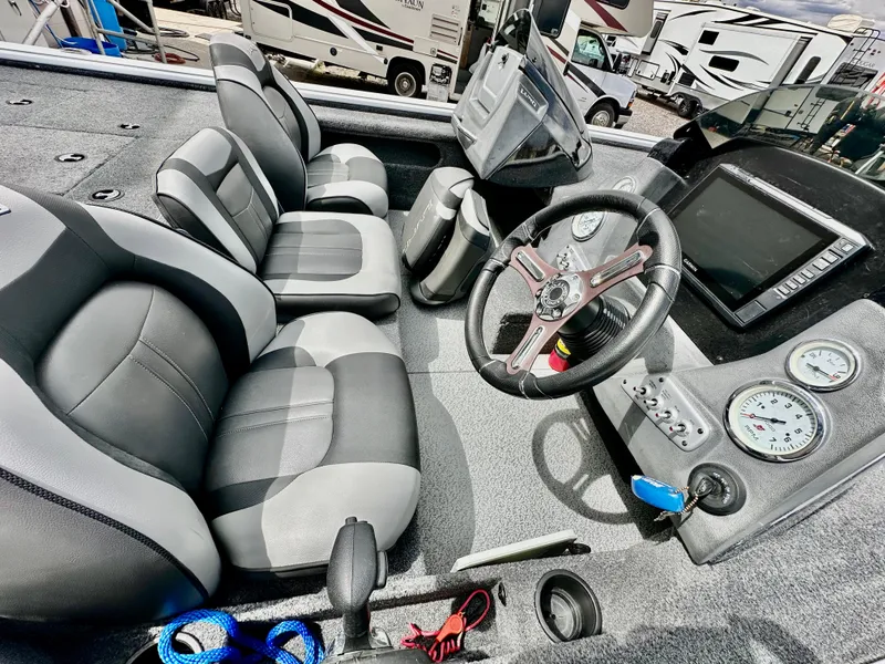 Slide: The Image of 2018 Lund 1875 Pro-V Bass boat interior with steering wheel and seating. - 8
