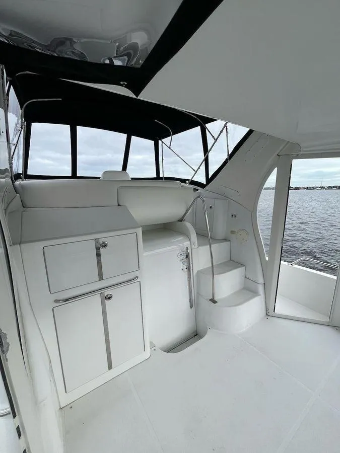 Slide: The Image of 2000 Carver 396 Motor Yacht interior with white cabinetry and steps, overlooking water. - 7