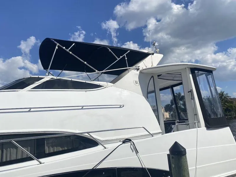 Slide: The Image of 2000 Carver 396 Motor Yacht with canopy, docked under a blue sky. - 9