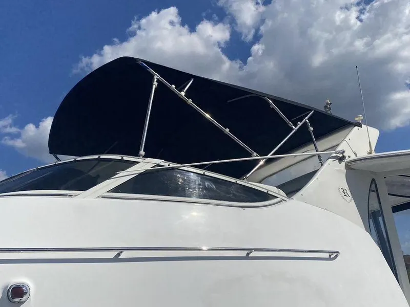 Slide: The Image of 2000 Carver 396 Motor Yacht with canopy against a cloudy sky. - 10