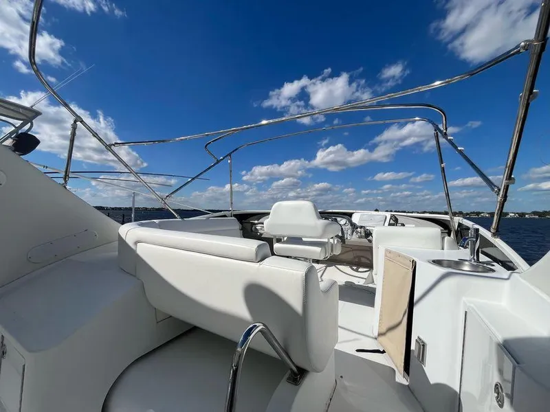 Slide: The Image of 2000 Carver 396 Motor Yacht deck with white seating under a clear blue sky. - 16