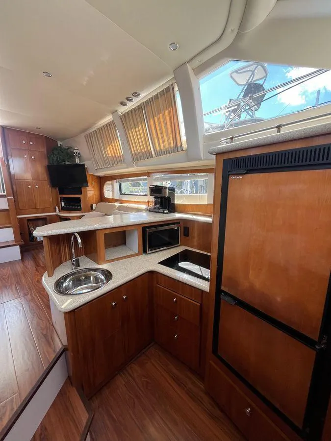 Slide: The Image of Interior of 2000 Carver 396 Motor Yacht with modern kitchen and wood finishes. - 21