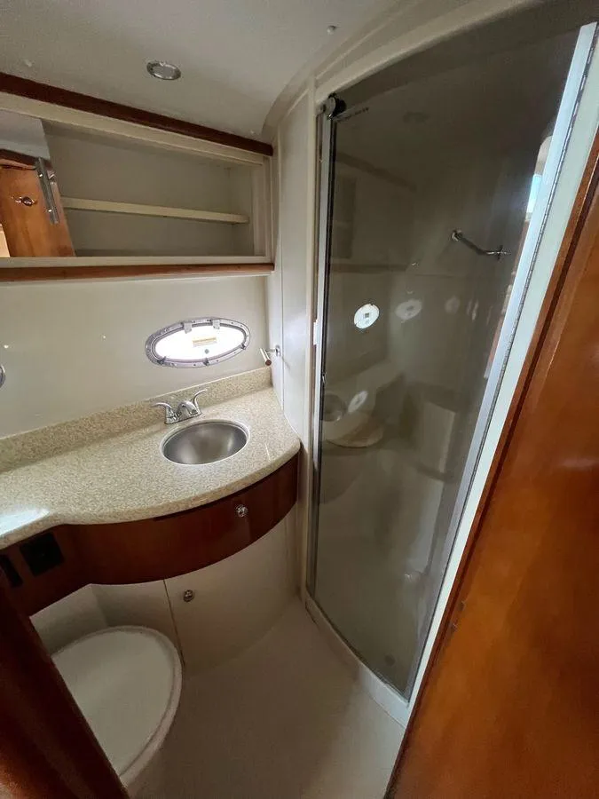 Slide: The Image of 2000 Carver 396 Motor Yacht bathroom with sink, shower, and storage shelves. - 28