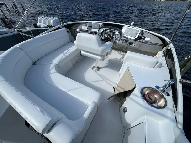 Slide: The Image of 2000 Carver 396 Motor Yacht cockpit with white seating and steering, overlooking water. - 3