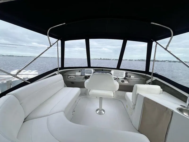 Slide: The Image of 2000 Carver 396 Motor Yacht interior with white seating and panoramic windows. - 5
